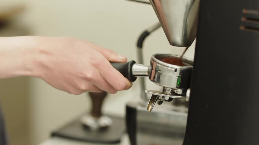 A woman makes coffee in a coffee shop