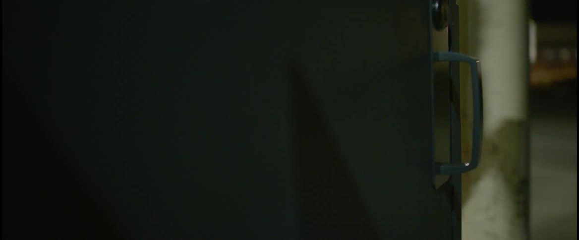 A person is walking into a store at night