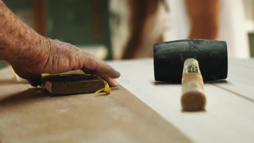 A man using a mallet on a wood table