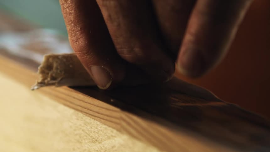 Carpenter applying white glue to a wooden surface