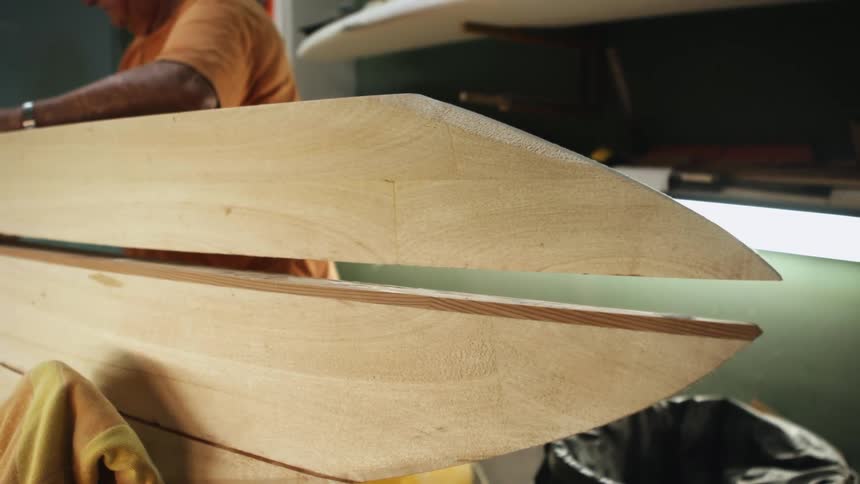 Man connects wooden pieces standing in workshop