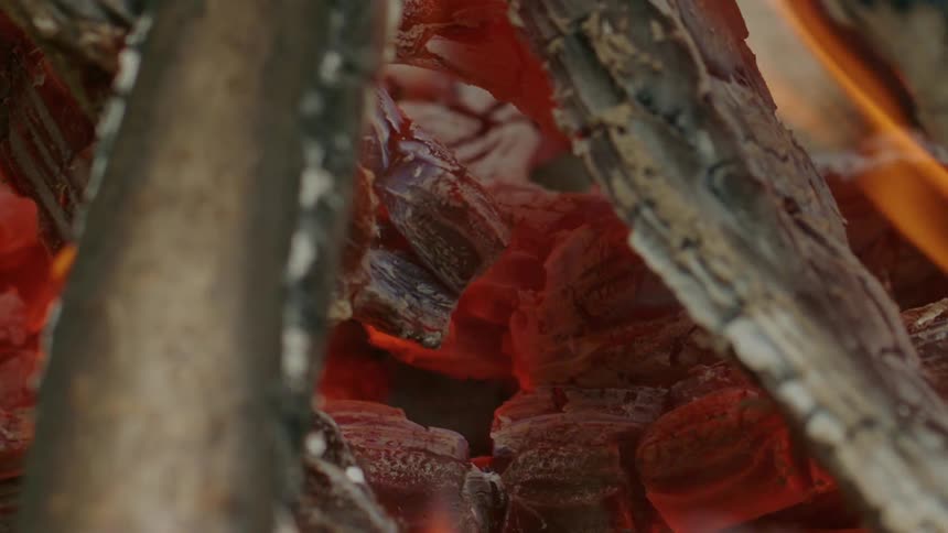 Flames rise on a bed of hot coals