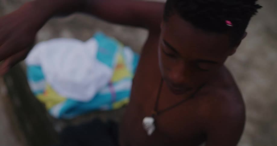 Teenage boy moving his arms in swimming motions on the beach