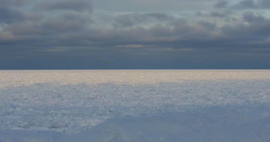 An open field is covered in a thick layer of snow and ice