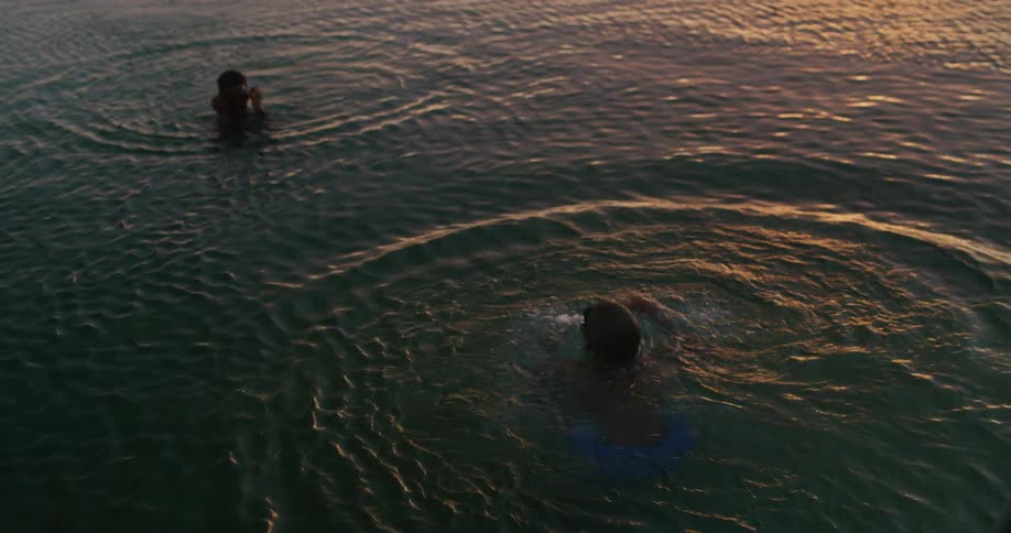 Two boys with goggles swimming and diving in water