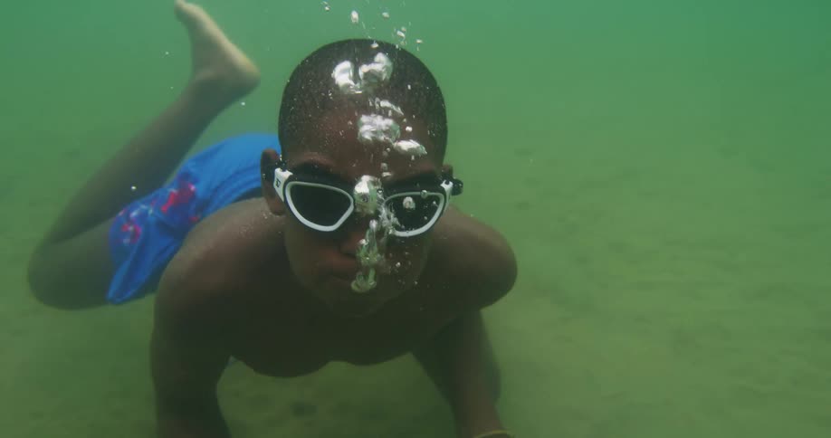 A kid is swimming in the ocean water