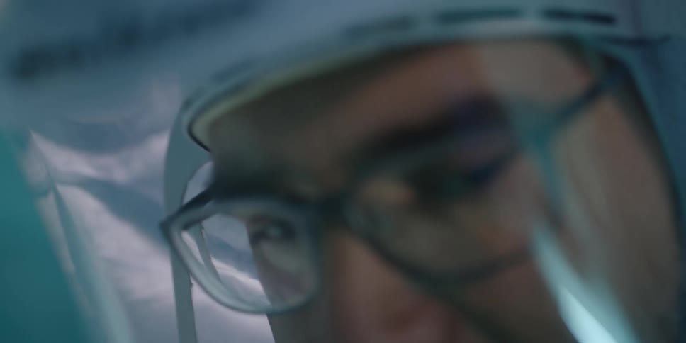 Two men are shown in full ppe as they have a discussion