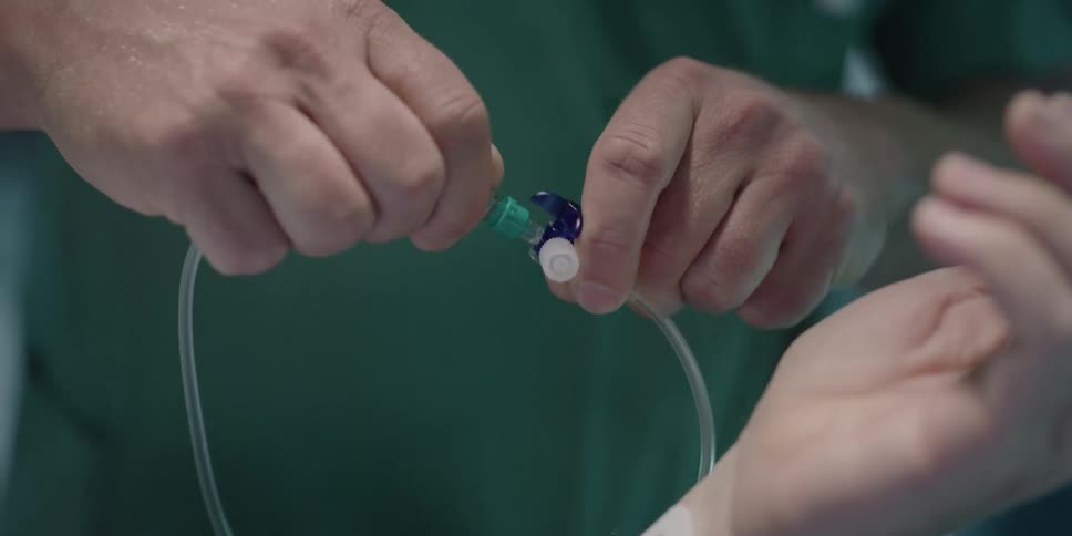 A doctor connecting tubes to a patient