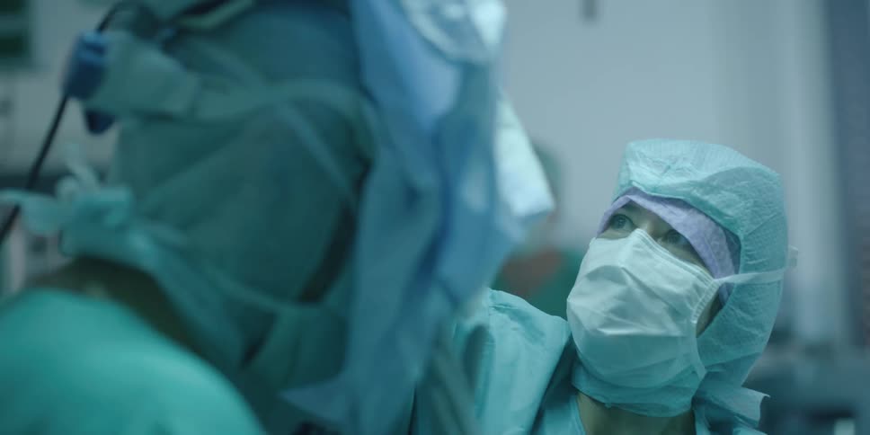 A woman puts a mask on a doctor in the hospital