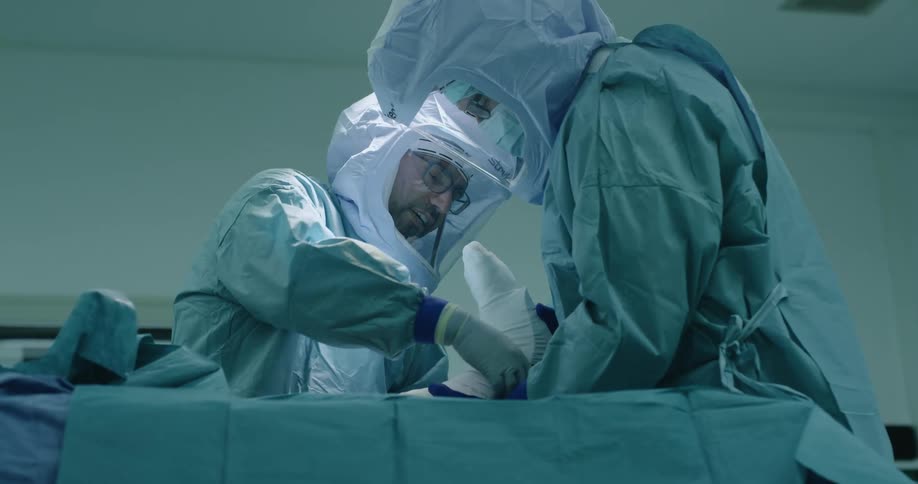 A nurse holds a patients foot as a doctor wraps it