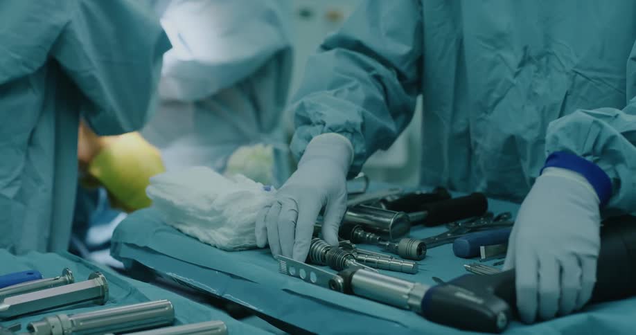 Surgeons and nurses prepare tools in the operating room