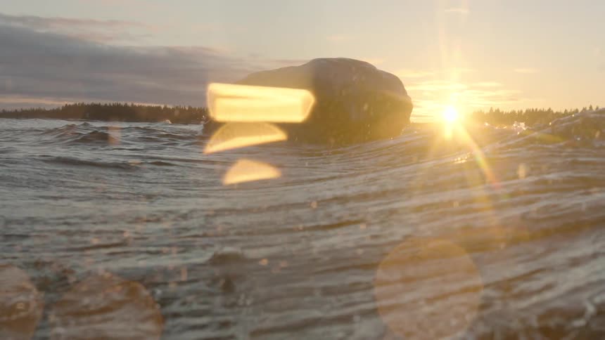 Ocean waves crash over a rock