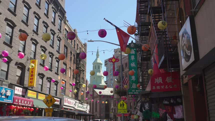 Lanterns hang on wires between buildings in a city during the day