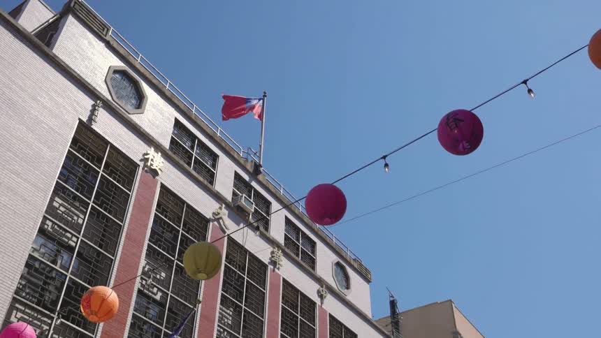 A building is revealed and there are paper lanterns hanging on the wire