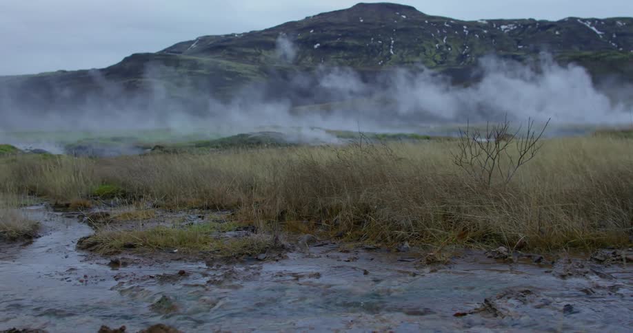 Steam arises from streams crossing a grassland