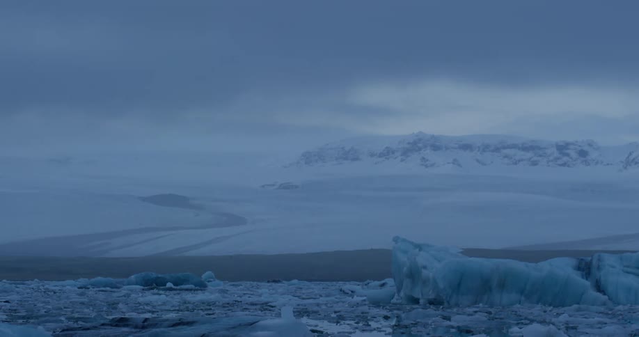 A snow and ice covered landscape under a dark sky