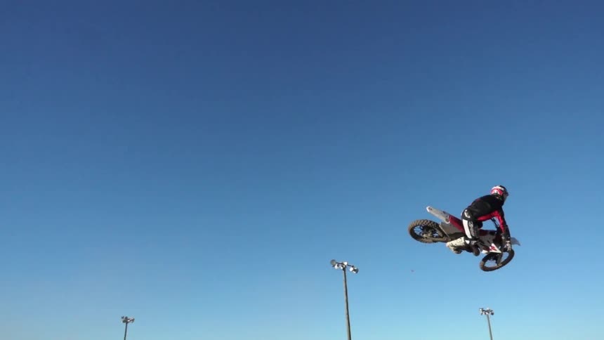 A man does a bike jump on a sunny day