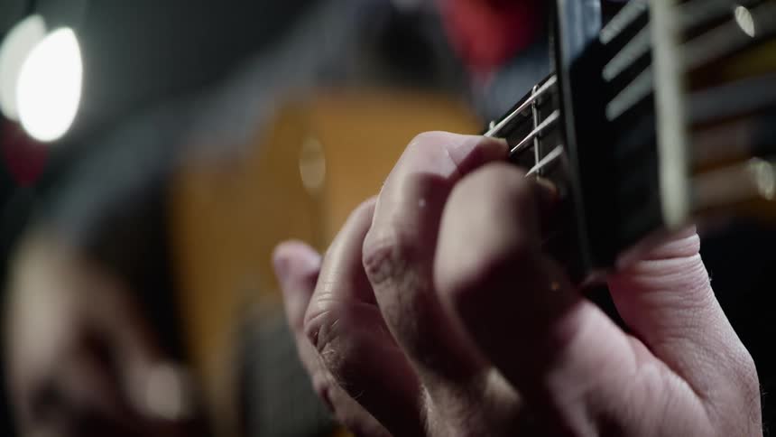 A man is playing the guitar during the night