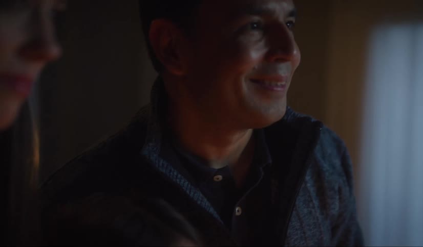 A man and woman are standing in a room at night