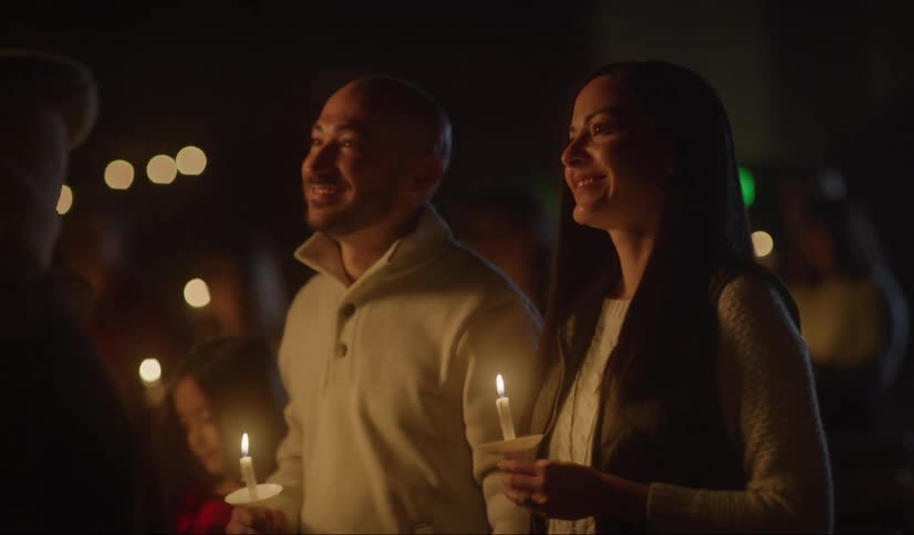 A man kisses his girlfriends hand during a candlelight vigil outdoors