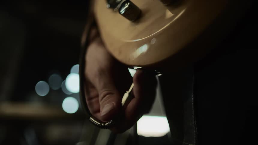 A musician plugs a jack into his electric guitar