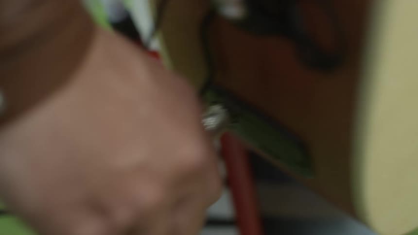 A person plugging their instrument into an amp