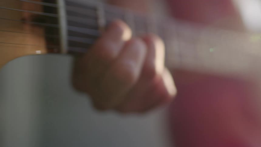A person is playing the guitar outdoors