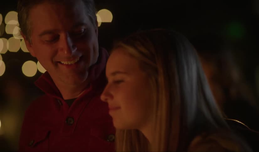 A man and woman are looking at something as they smile