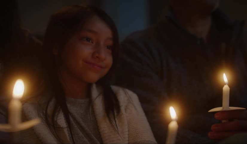 People are holding candles in the dark ceremony