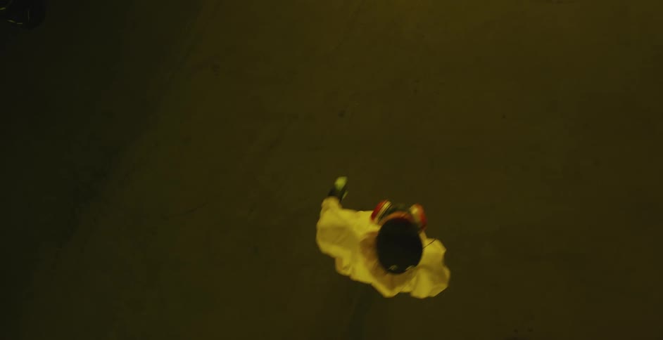 Young man wearing a yellow hazmat suit enters a building