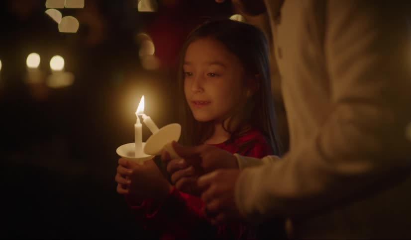Family lighting candles for prayer in a vigil at night