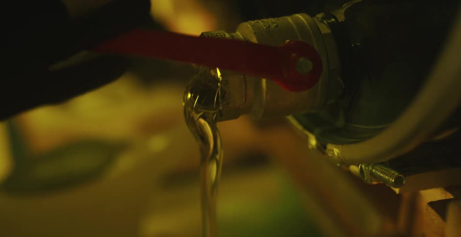 A person in a room turning on a spigot with a clear gel oozing out into a container