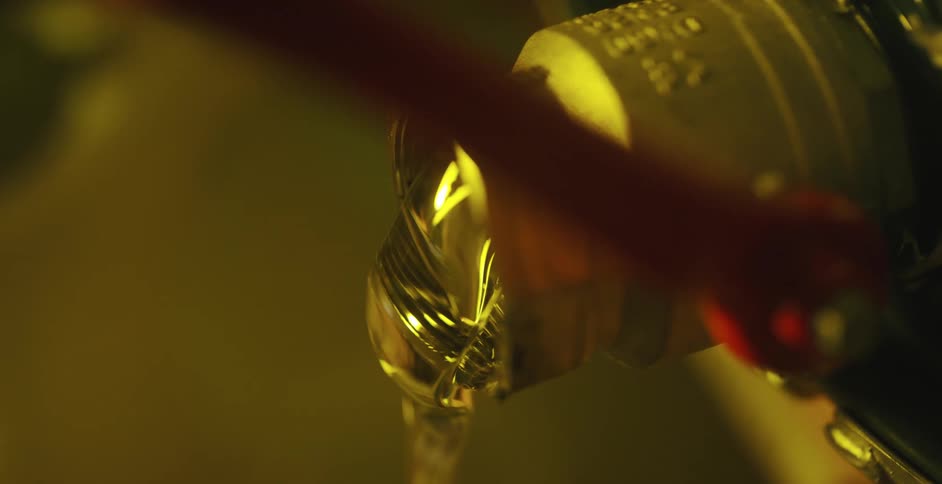 A hand pulls a lever and a thick substance comes out of the spout