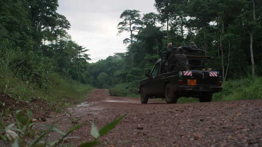 A truck drives down a dirt trail