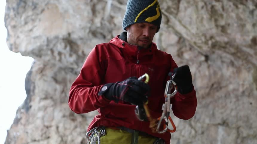 A man is lifting some buckles and removing one