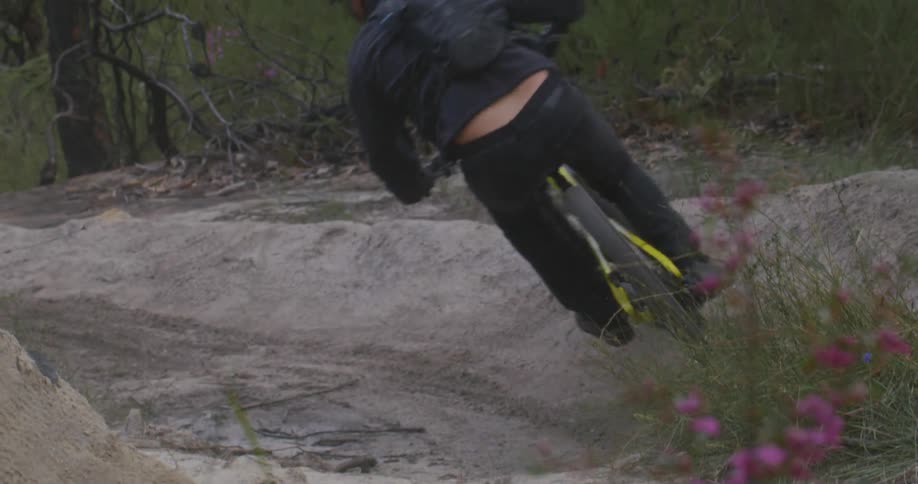 A mountain bike rider rides a dirt course through the forest