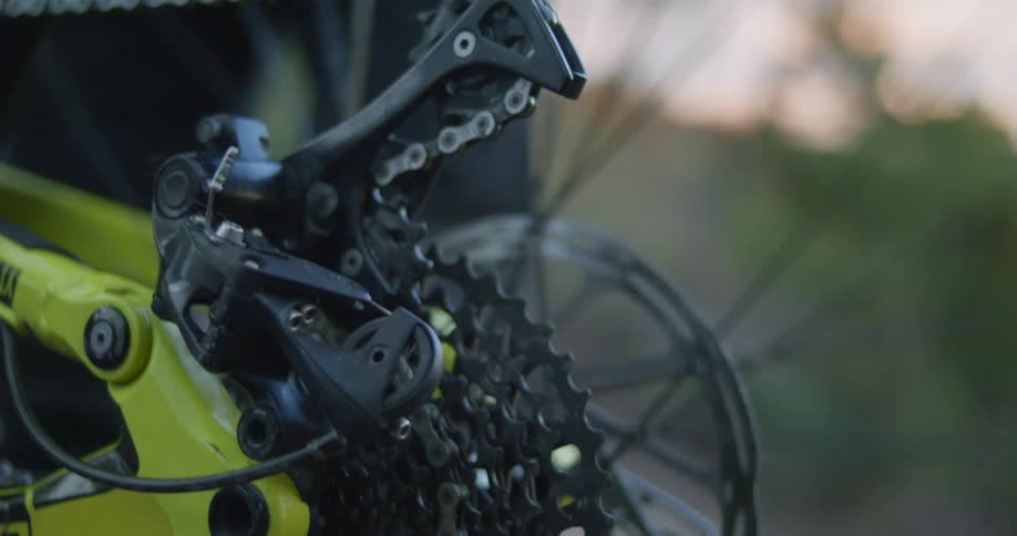 A person with gloves fixing the gears on a bicycle wheel