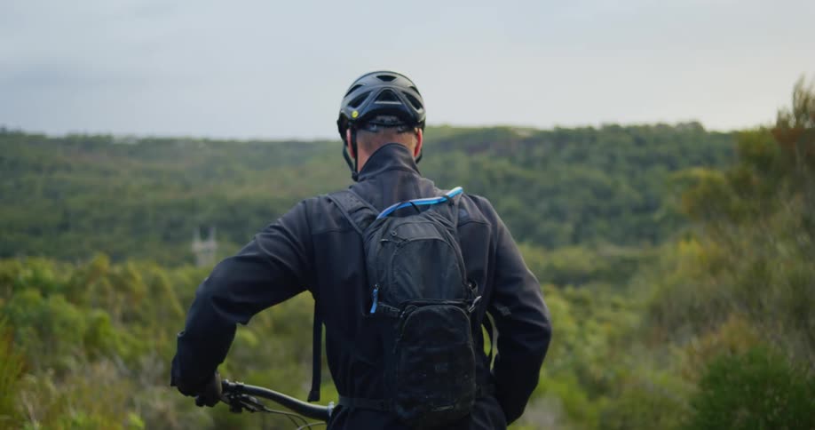 A man with a bicycle walking outdoors