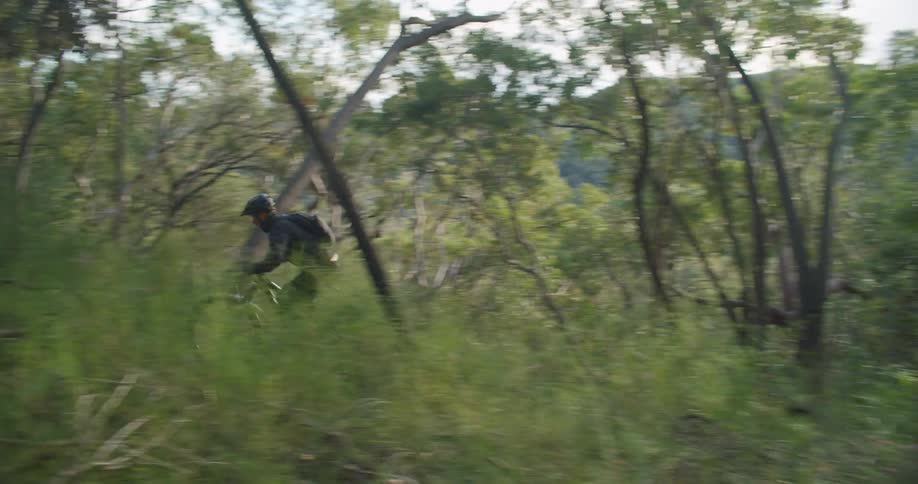 Man riding a bicycle on a trail through the hills at morning