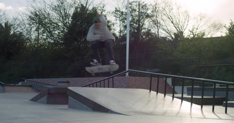 A young male rides a skateboard up a ramp and then does a 360 flip