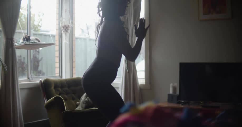 A woman is doing exercises inside of her home