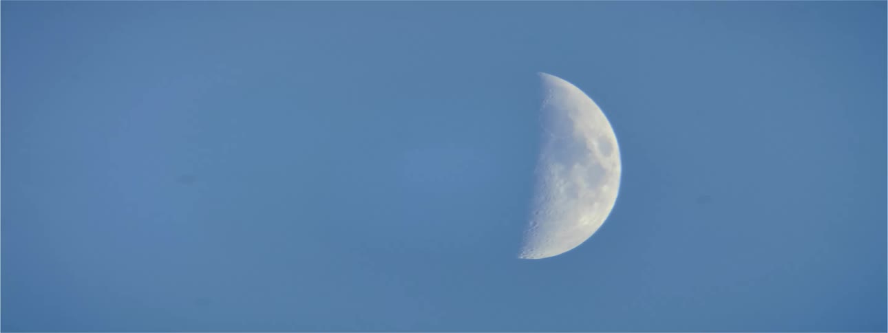 Half a moon in the sky during the day