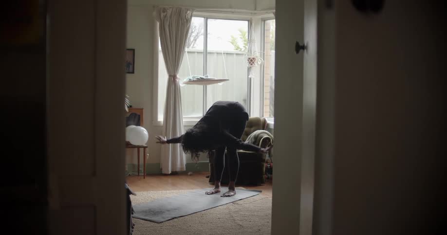 Woman stretches and bends before taking yoga pose on mat