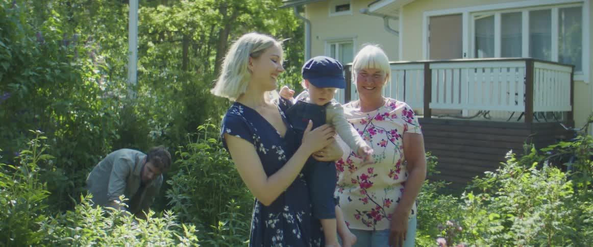 Family plucks flowers and examines garden while talking