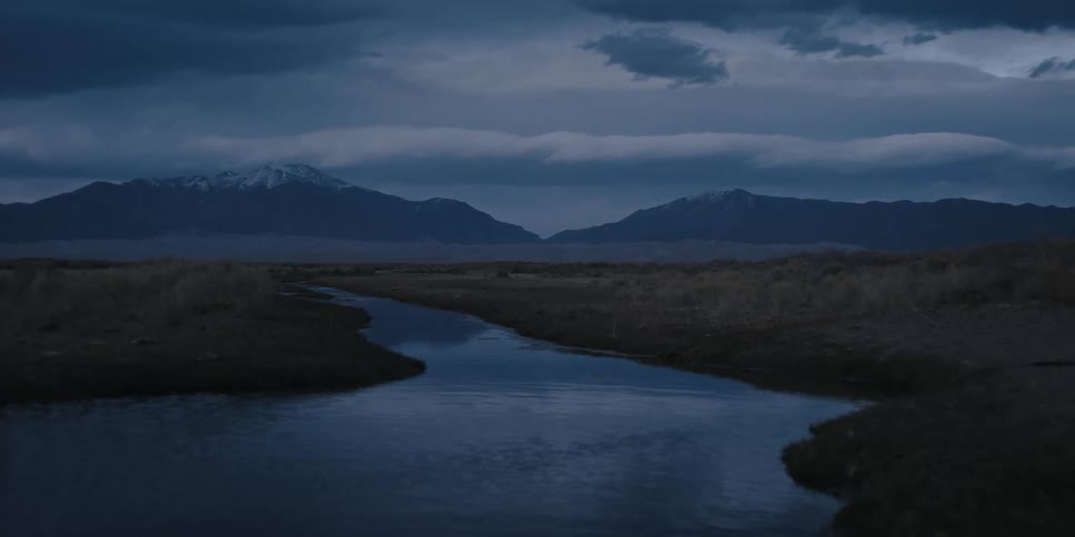 River flowing through the hills near the mountains at evening