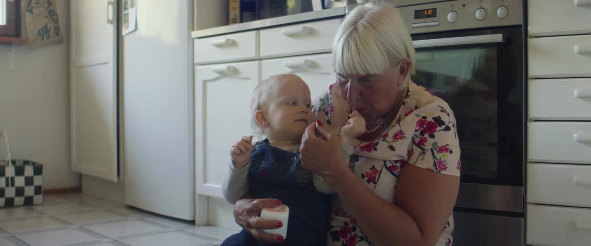A grandmother and child playing in a kitchen