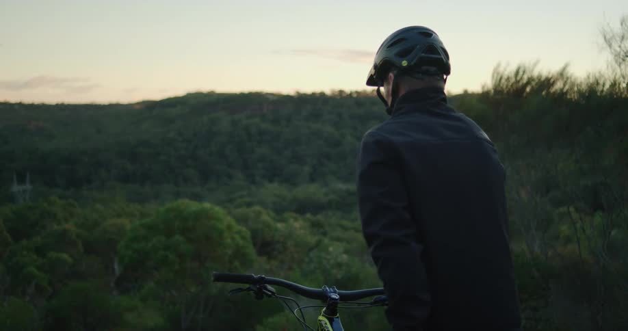 A man is stopped on the hill on his bicycle