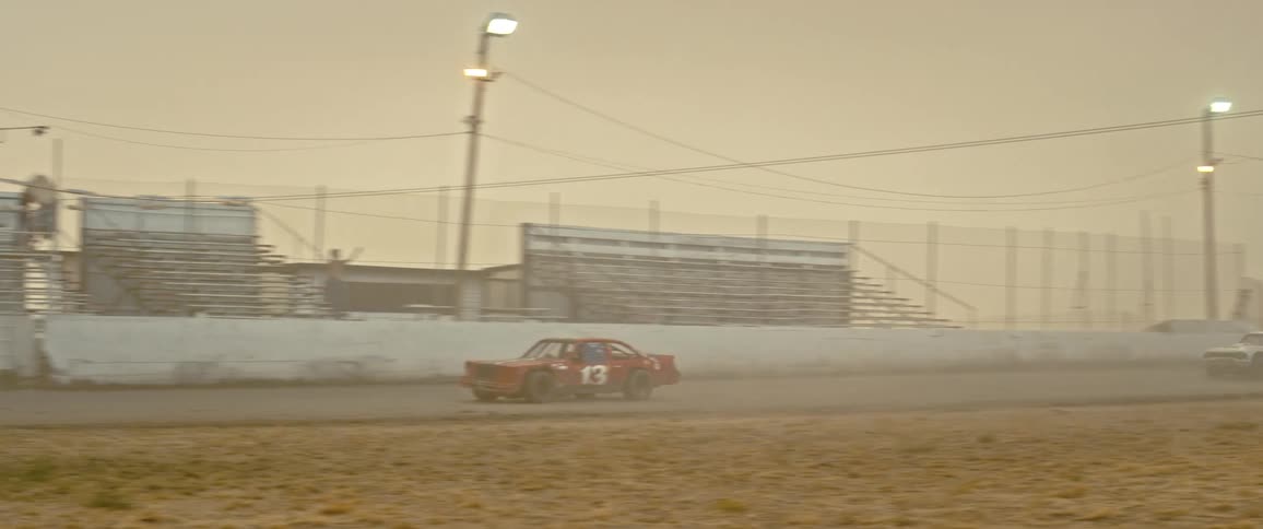 Racing cars crossing under the waving flag on the finish line at sunset