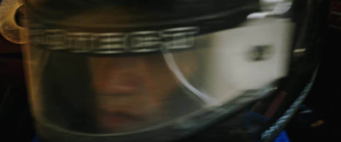 A man in racing gear looking around