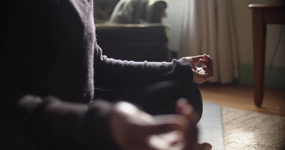 A woman is sitting on the floor and doing yoga